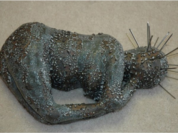 textured sculpture showing figure with spikes coming out of head